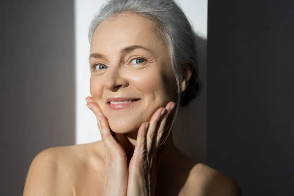 Mature woman smiling with hand at her face — Stock Photo, Image
