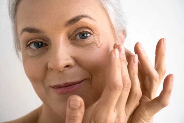 Mujer pipeteo rejuvenecimiento aceite en la cara con las manos — Foto de Stock