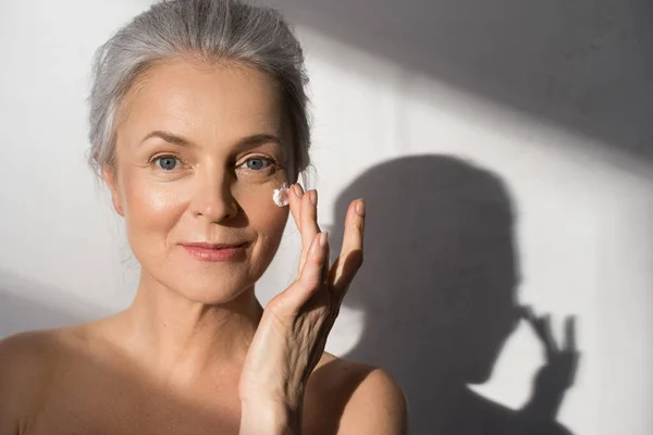 Žena nanáší kosmetický krém na čistý hydratovaný kožní portrét — Stock fotografie