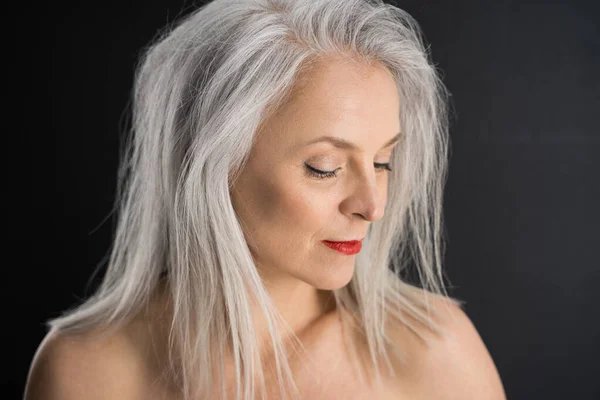 Mature woman with red lips looking down isolated on black background — Stock Photo, Image