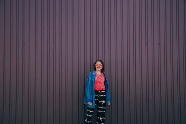 Frau steht vor der großen Stadtmauer und posiert auf der Straße — Stockfoto