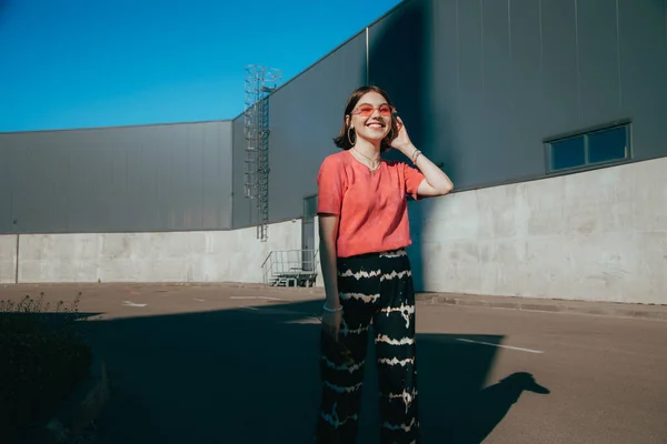 Mädchen in rosa T-Shirt und Brille posiert auf Gasse und genießt den Sommer — Stockfoto