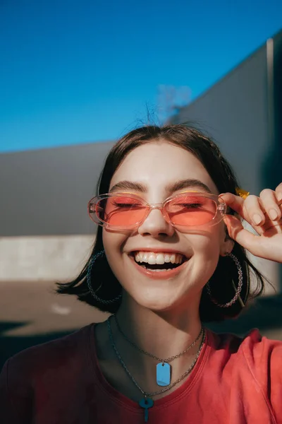 Tiener het dragen van een zonnebril glimlachen breed met gesloten ogen terwijl de zomer — Stockfoto