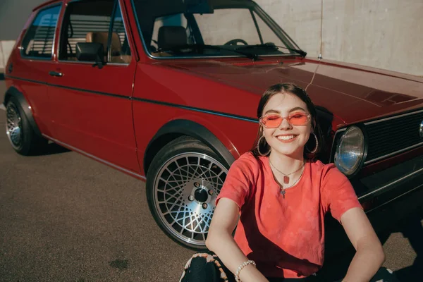 Mujer sonriendo a la cámara y sintiéndose feliz mientras pasa tiempo en la calle —  Fotos de Stock