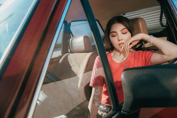Girl pondering while sitting behind the wheel at the drivers seat — Stock Photo, Image