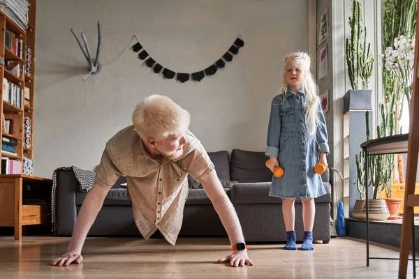 Ragazza in piedi nella stanza e guardando con interesse suo padre — Foto Stock