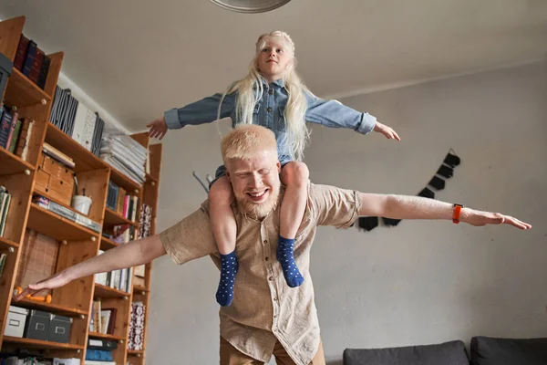 A szülő a kezében tartja a gyereket, miközben a gyerek felemeli a karját, mint egy repülő. — Stock Fotó