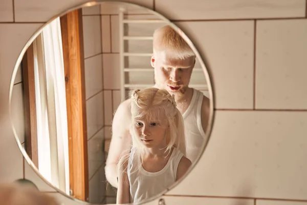 Man helpen bij de voorbereiding kapsel voor zijn kleine blonde dochter thuis — Stockfoto