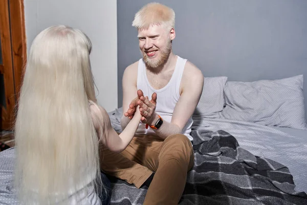 Man zittend aan het bed en hand in hand van zijn mooie dochter met blond haar — Stockfoto