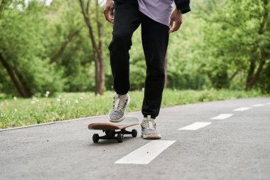 Kıvırcık saçlı, kaykaylı ya da yeşil parktaki kaykaylı bir adam.