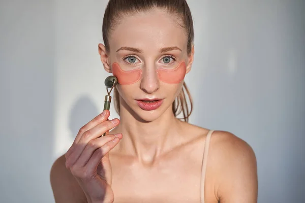 Mujer con piel de vitiligo usando máscara cosmética bajo los ojos para prevenir arrugas — Foto de Stock