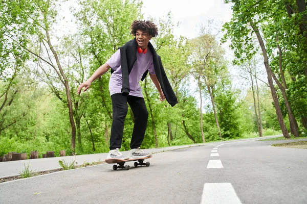 Uomo cercando skateboard mentre godendo di sport estremi alla strada urbana — Foto Stock