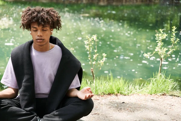 Uomo meditare al parco al mattino e praticare yoga mentre seduto a terra — Foto Stock