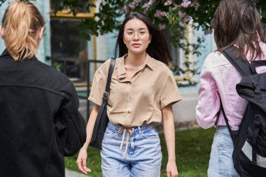 Kız yaz günü sokakta yürürken kalabalığın arasında yürüyor.