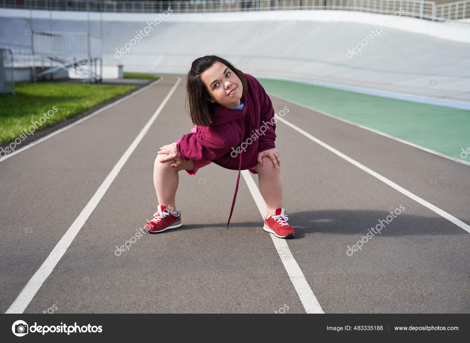 Midget woman slowly warming up before training at stadium Stock Photo by  ©iakovenko123 483335188