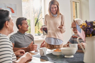Hemşire huzurevinde çalışırken emeklilere çay ikram ediyor.