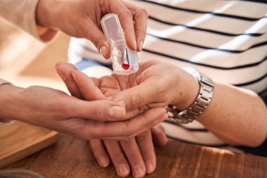 Hademenin, yaşlı bir kadına avuç içinden ilaç çekmesi.