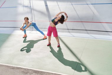 Cüce kadın stadyumdaki antrenman sırasında arkadaşıyla vakit geçiriyor.