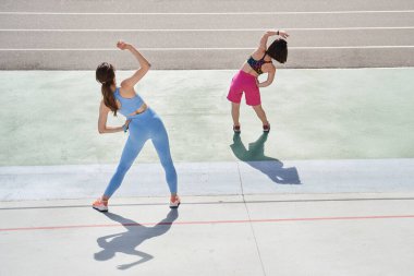 Stadyumda farklı kızlar çarpışırken, yamaçlarda koşuyorlar ve esnek hissediyorlar.