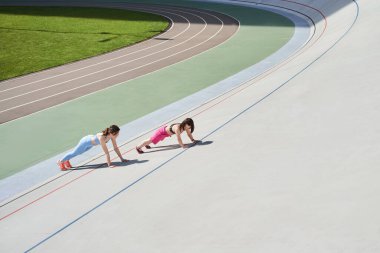 Kız cüce kız arkadaşıyla stadyumda planking egzersizi yapıyor.