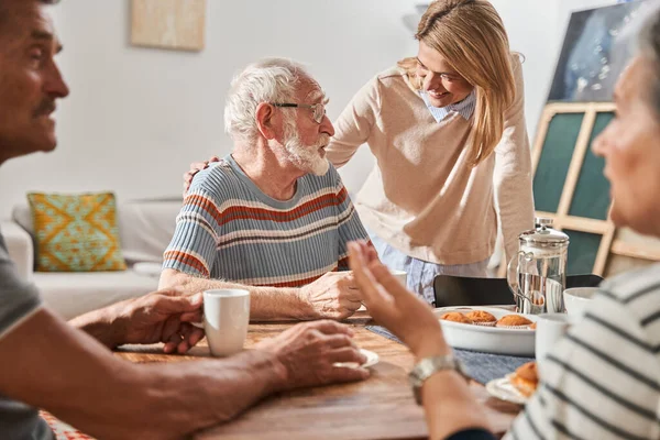 Senior man and embracing him at the shoulder while working with group of elderly people — Stock Photo, Image