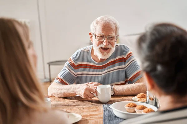 Idősebb ember hangosan nevet, miközben a barátaival beszél a nyugdíjas otthonban. — Stock Fotó