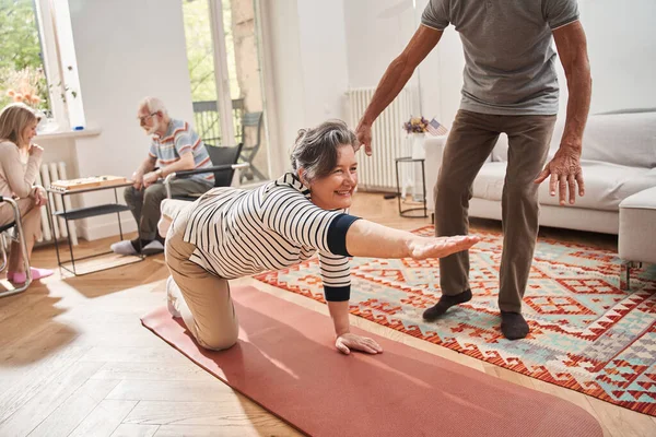 Seniorin lächelt und macht Morgengymnastik im Pflegeheim — Stockfoto