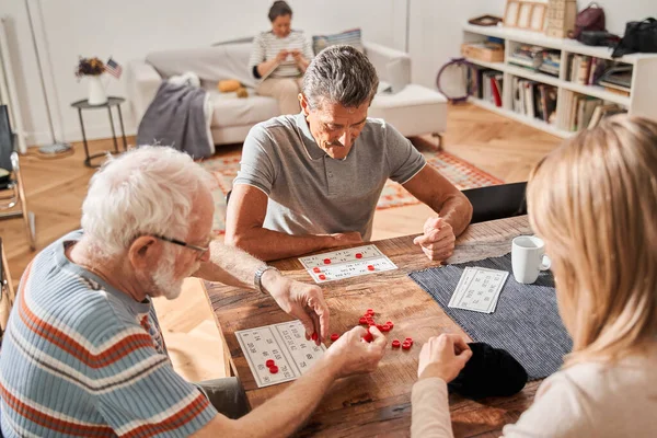 Oudere patiënten van begeleid wonen thuis bijeenkomst aan tafel in de woonkamer — Stockfoto