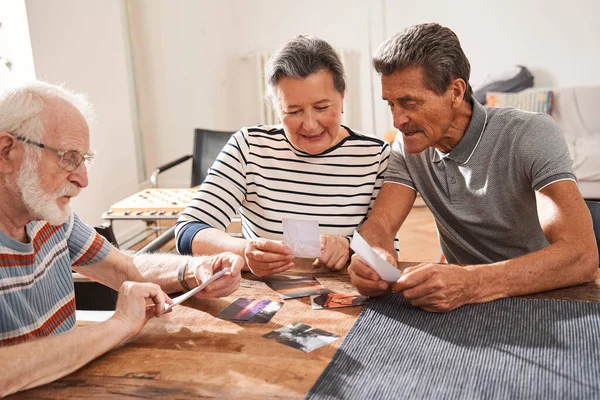 Vrouw die een foto vasthoudt en ernaar kijkt terwijl ze tijd doorbrengt in het verpleeghuis — Stockfoto