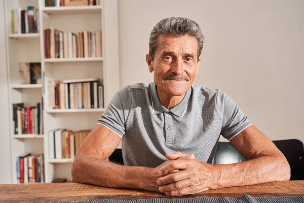 Hombre mirando atentamente a la cámara con sonrisa de placer — Foto de Stock