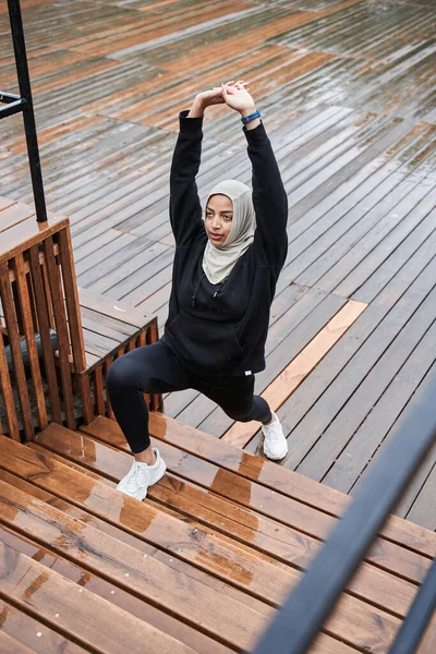 Muzułmanka ubrana w sportowe ubrania ćwiczy rozciąganie — Zdjęcie stockowe