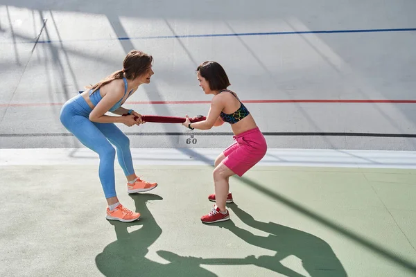 Best friends standing in front of each other while tug of towel like a war — Stock Photo, Image