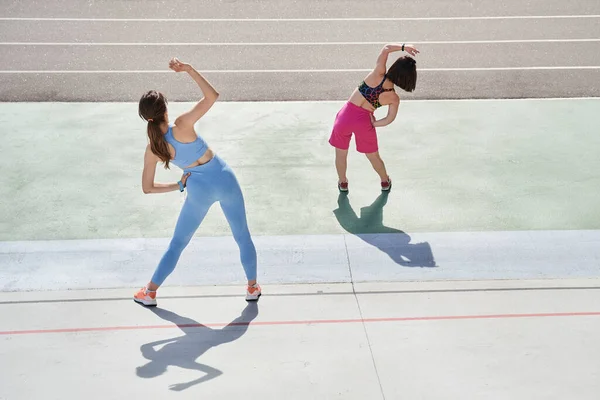 Diverse meisjes bezig in het stadion, terwijl het doen van hellingen en het gevoel flexibel — Stockfoto