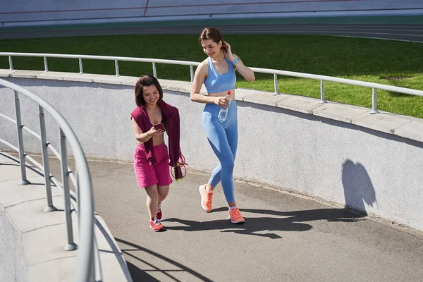 Egy lány sétál a stadionban a legjobb barátjával futás után. — Stock Fotó