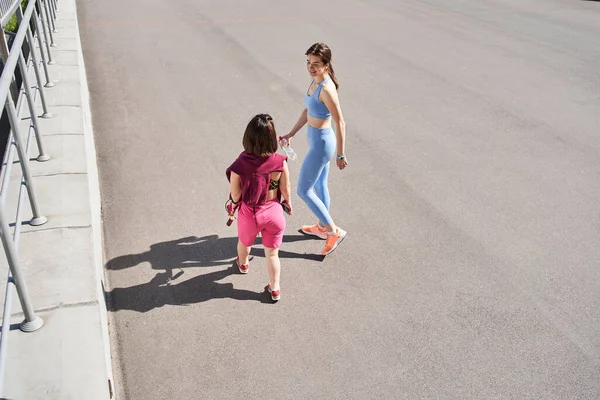 Diverse meisjes kijken weg tijdens het wandelen in het stadion en ontspannen na de training — Stockfoto