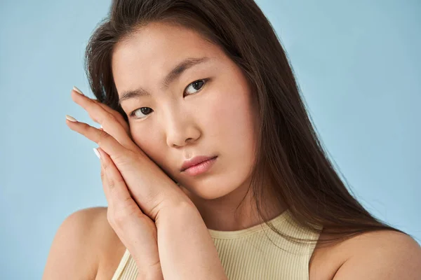 Vrouw kijkt dromerig naar de camera en houdt haar handen bij het gezicht — Stockfoto