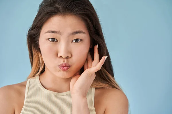 Vrouw die naar de camera kijkt en grappige gezichten trekt tijdens fotoshoot — Stockfoto