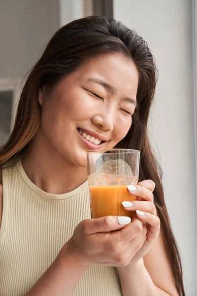 Retrato de una joven riendo que se prepara para beber jugo de naranja o zanahoria — Foto de Stock