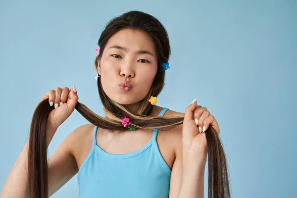 Vrouw genieten van haar lange sterke haar en pruilen lippen terwijl kijken naar de camera — Stockfoto