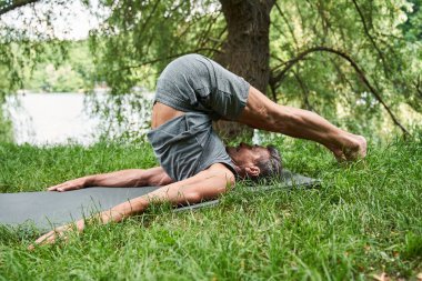Son sınıf öğrencisi antrenmandan önce yoga minderinde egzersiz yapıyor.