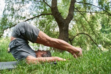 Son sınıf öğrencisi antrenmandan önce yoga minderinde egzersiz yapıyor.