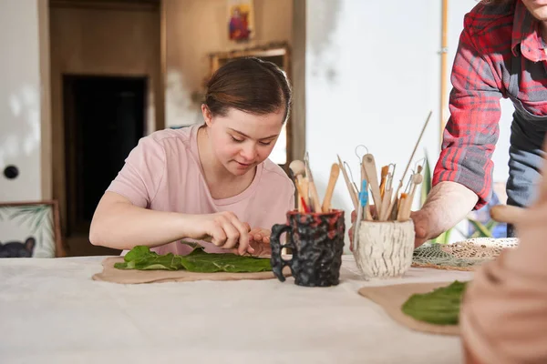 Dívka s Downovým syndromem, aby její vlastní produkt, zatímco tráví čas na mistrovské třídě — Stock fotografie