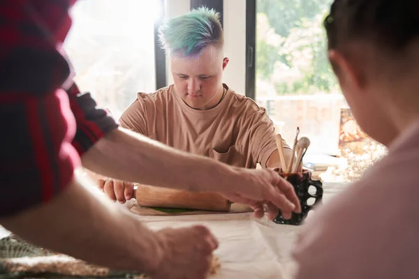 Uomo con i capelli colorati stendere foglia fresca sopra l'argilla per fare un'impressione — Foto Stock