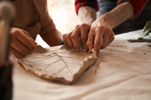 Sculpteur façonne une plaque d'argile tout en travaillant à la classe de maître pour les personnes — Photo