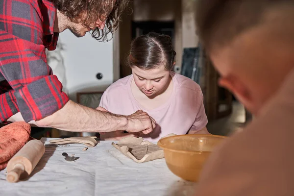 Fille avec des besoins spéciaux regardant attentivement son mentor tout en préparant sa propre assiette — Photo