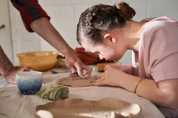 Fille faisant soigneusement plaque de l'argile sous la supervision du mentor — Photo