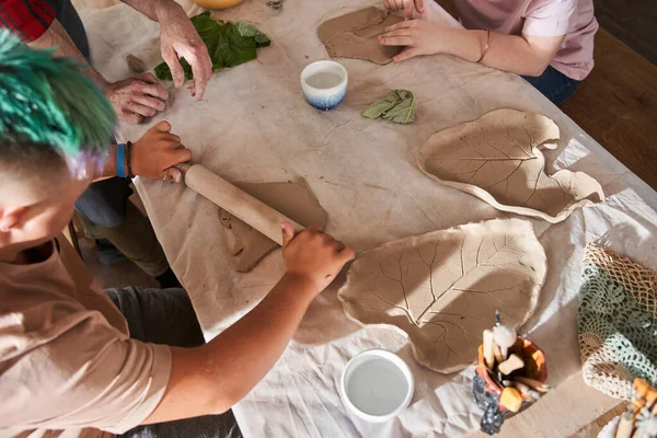 Zelfverzekerde beeldhouwer helpen om de jongen met speciale behoeften maken van zijn eerste bord — Stockfoto
