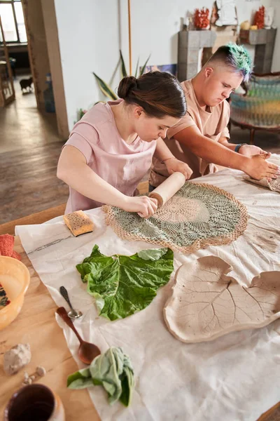 下症候群の女の子は粘土で装飾を印刷するために圧延パンを使用して — ストック写真