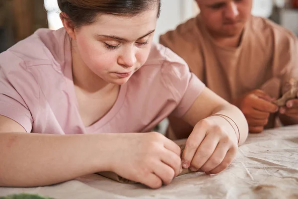 Niño con necesidades especiales examinando su plato de la arcilla y esperando a su novia — Foto de Stock