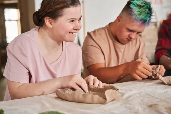 Ragazza ridendo ad alta voce mentre si sente felice durante la classe master di ceramica — Foto Stock